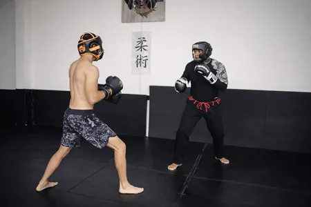 Sparring técnico de boxeo con equipo de protección en dojo de jiu jitsu